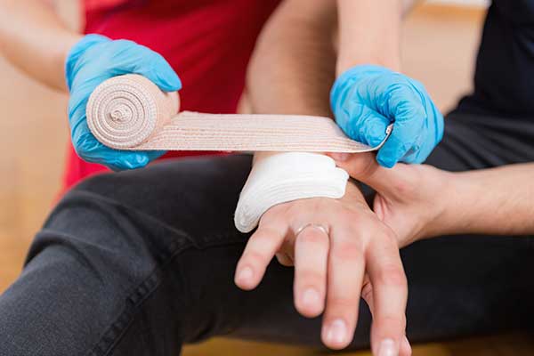 Applying a Bandage to Hand during Emergency First Aid at Work Course.