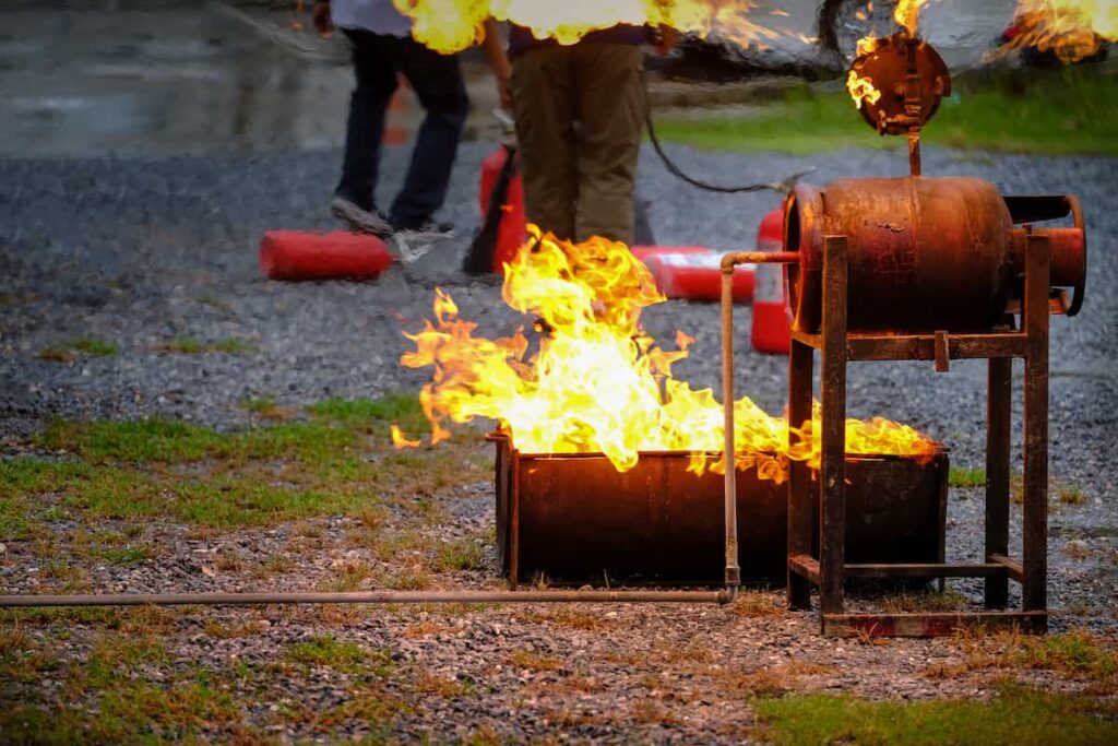 Instructor showing how to use a fire extinguisher on a training fire